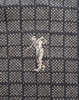 Close-up of a textured fabric with a small embroidered 